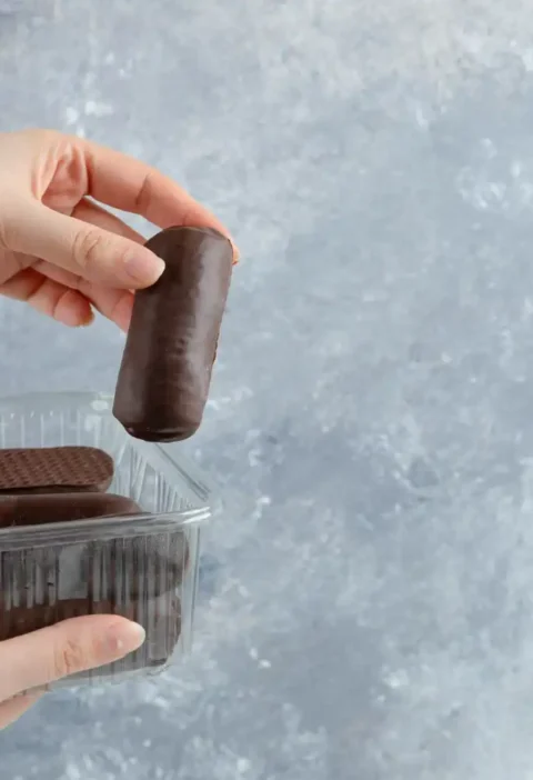 Embalagem blister de chocolate sendo aberta, destacando a diferenciação no ponto de venda para impulsionar o sucesso nas vendas online.