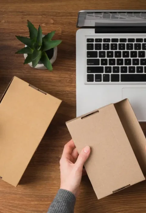 Pessoa montando caixa de papelão com divisórias para proteger produtos no e-commerce, ideal para reduzir quebras nas entregas.