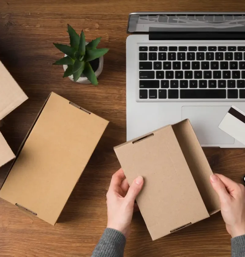 Pessoa montando caixa de papelão com divisórias para proteger produtos no e-commerce, ideal para reduzir quebras nas entregas.