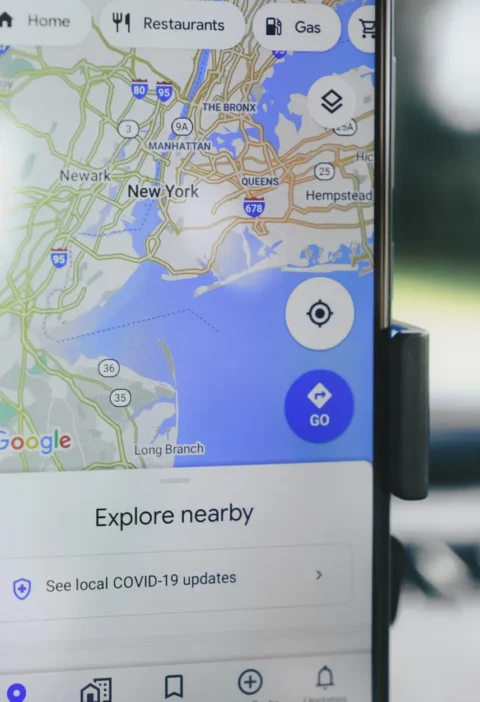 Celular com o aplicativo Google Maps aberto, exibindo mapa e opção de navegação “Explore nearby”, uma dica sobre como aparecer no Google Maps e em respostas de IA em Curitiba.