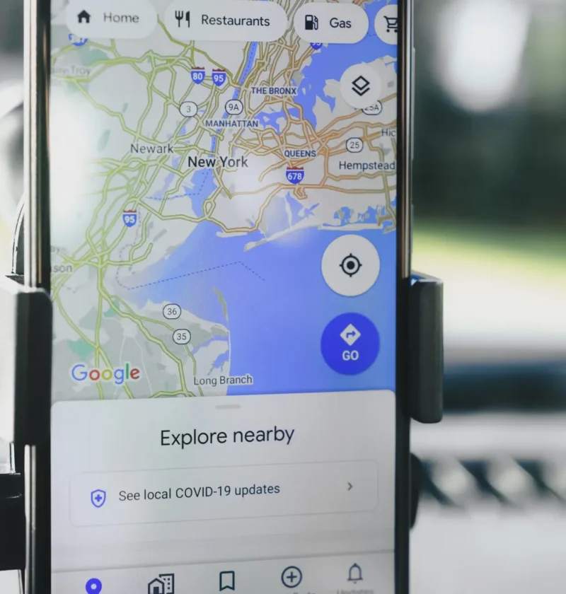 Celular com o aplicativo Google Maps aberto, exibindo mapa e opção de navegação “Explore nearby”, uma dica sobre como aparecer no Google Maps e em respostas de IA em Curitiba.