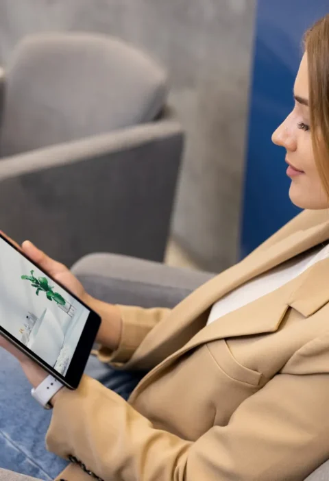 Mulher usando tablet em ambiente de trabalho, com a tela exibindo o texto “Deor”, enquanto navega em tecnologia no dia a dia; As Principais tendências de tecnologia que estão transformando o cotidiano.