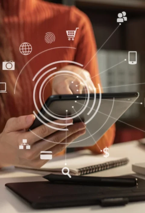 Pessoa usando tablet com ícones digitais e conexão de rede ao fundo, representando Transformação Digital: Como empresas estão se adaptando ao novo consumidor em um ambiente de trabalho moderno.